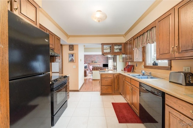 kitchen with black appliances, under cabinet range hood, light countertops, and crown molding