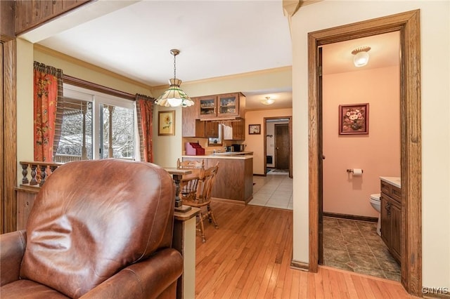 dining space featuring light wood-style floors, baseboards, and crown molding