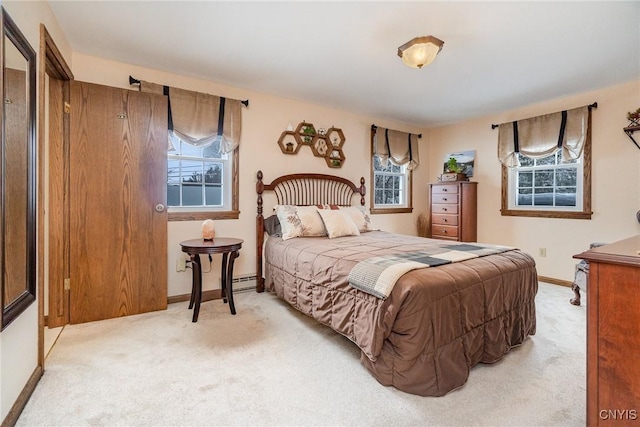 bedroom featuring baseboard heating, light carpet, and baseboards