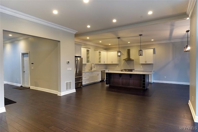 kitchen featuring visible vents, dark wood-style flooring, stainless steel appliances, light countertops, and wall chimney range hood