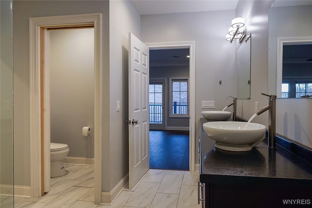 bathroom with baseboards, toilet, and vanity