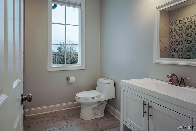 bathroom with baseboards, toilet, and vanity