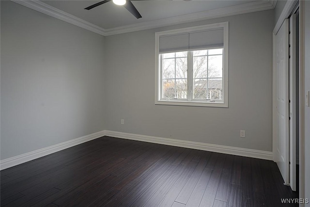 unfurnished bedroom with baseboards, dark wood-type flooring, ornamental molding, and a ceiling fan