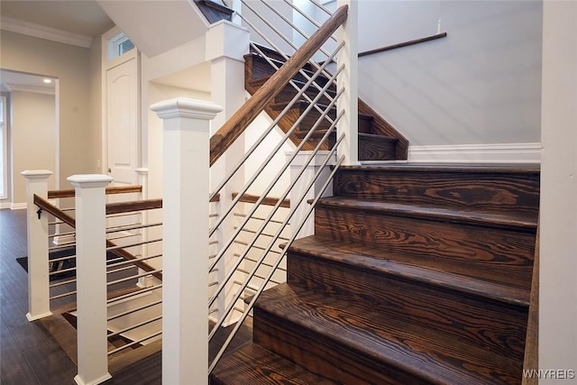 stairs with crown molding, baseboards, and wood finished floors