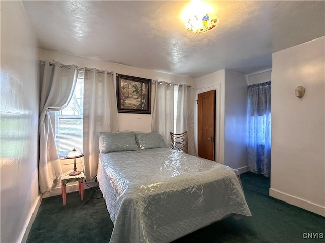 bedroom with baseboards and dark carpet