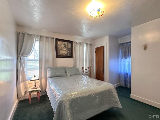 bedroom featuring dark colored carpet and baseboards