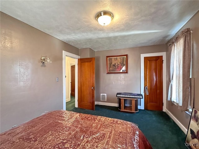 unfurnished bedroom with a textured ceiling, dark colored carpet, visible vents, and baseboards