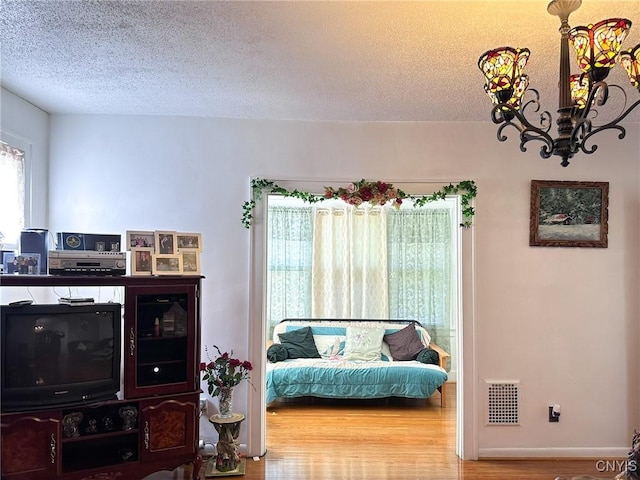 sitting room featuring a textured ceiling, visible vents, and wood finished floors