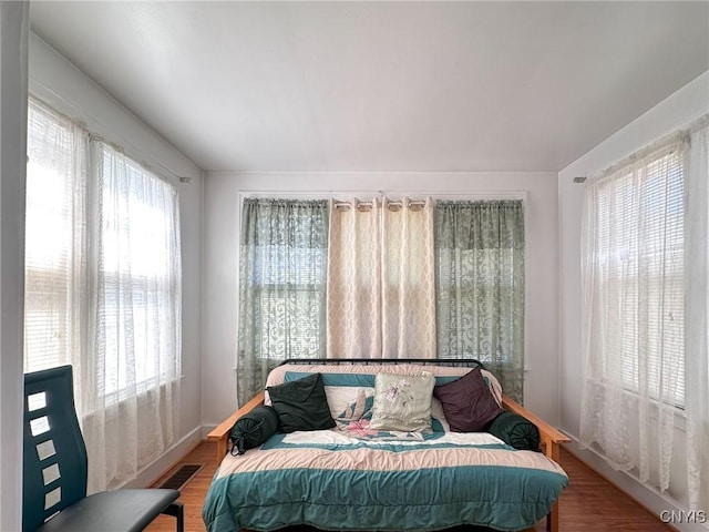 bedroom featuring multiple windows, visible vents, and wood finished floors