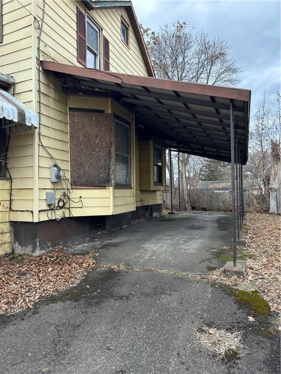 view of property exterior featuring aphalt driveway and an attached carport