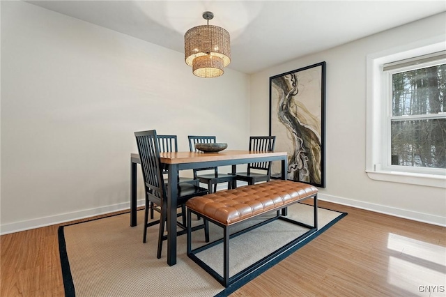 dining area with an inviting chandelier, baseboards, and wood finished floors