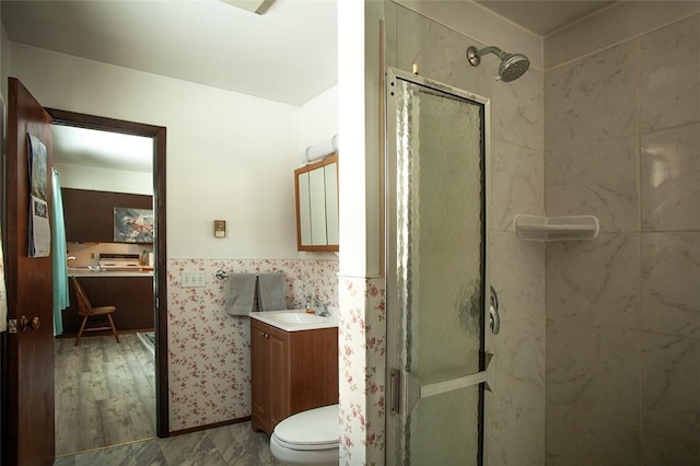 bathroom featuring toilet, a shower stall, and vanity