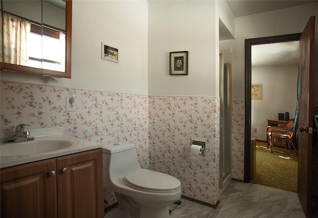 bathroom with wainscoting, a shower stall, toilet, and vanity