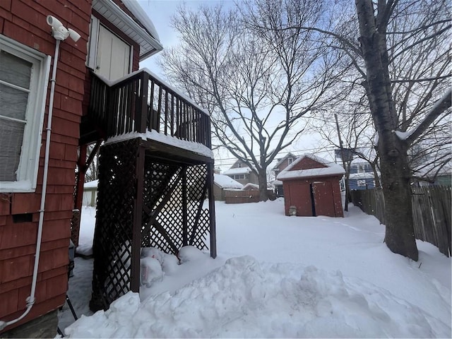 yard covered in snow featuring an outdoor structure and fence