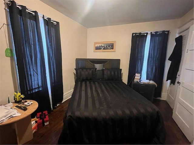 bedroom with baseboards and wood finished floors