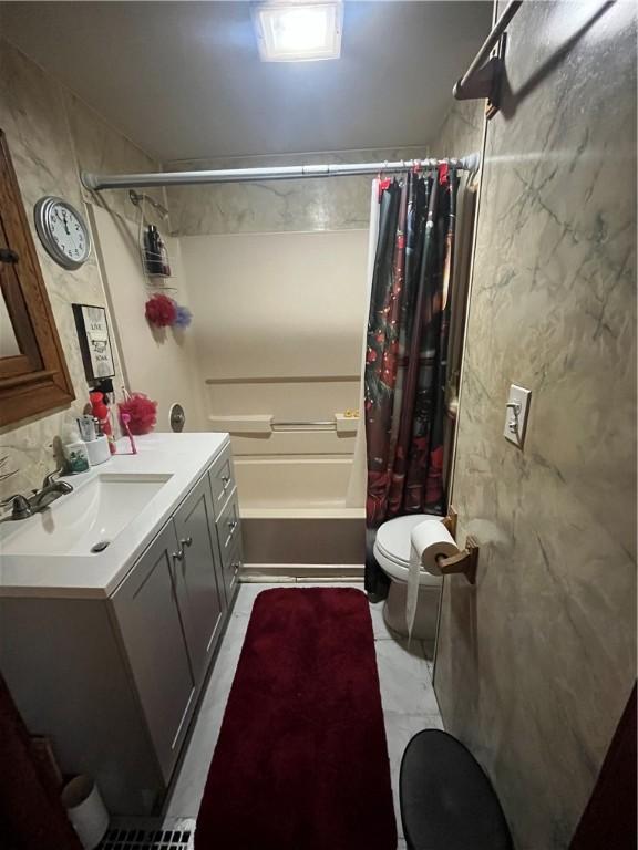 bathroom with toilet, shower / bathtub combination with curtain, and vanity