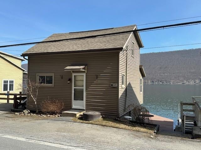 view of front of home featuring a water view and a shingled roof