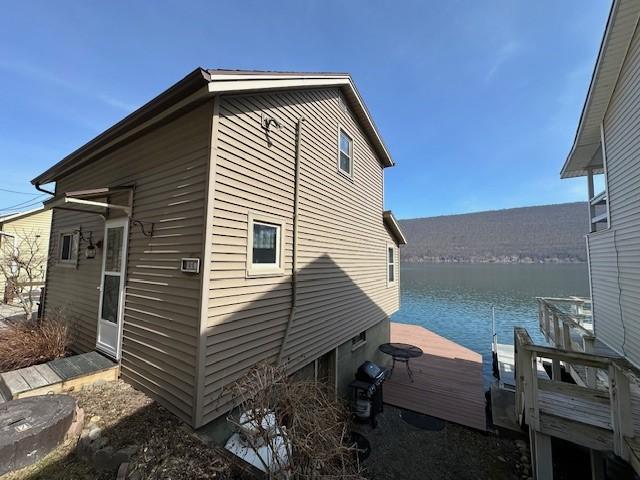 view of home's exterior featuring a water view and a boat dock