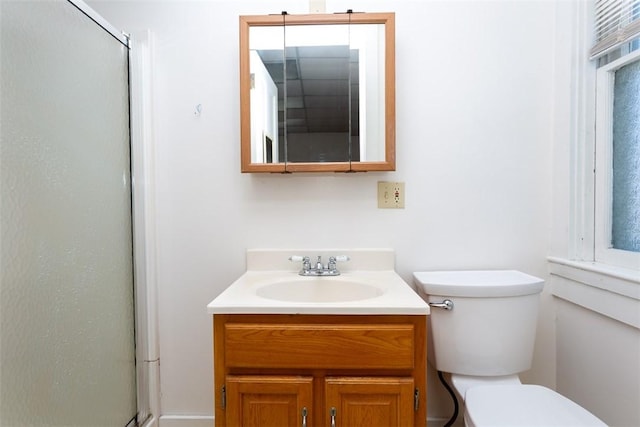 bathroom with a stall shower, vanity, and toilet