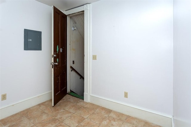 spare room featuring electric panel and baseboards