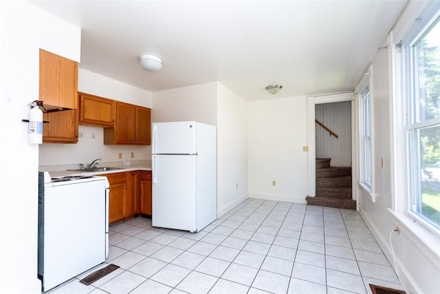 kitchen with light countertops, white appliances, plenty of natural light, and a sink