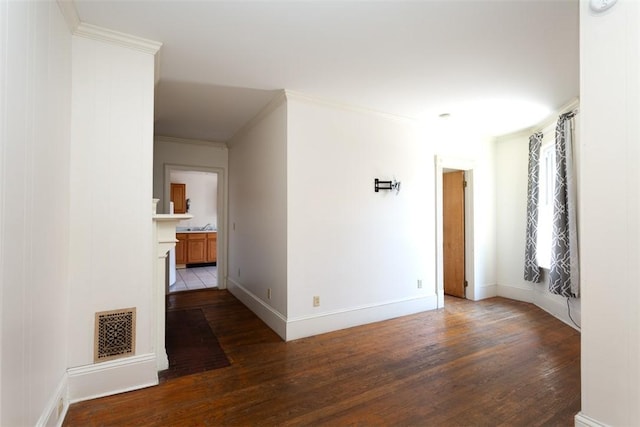 corridor with visible vents, crown molding, and wood finished floors