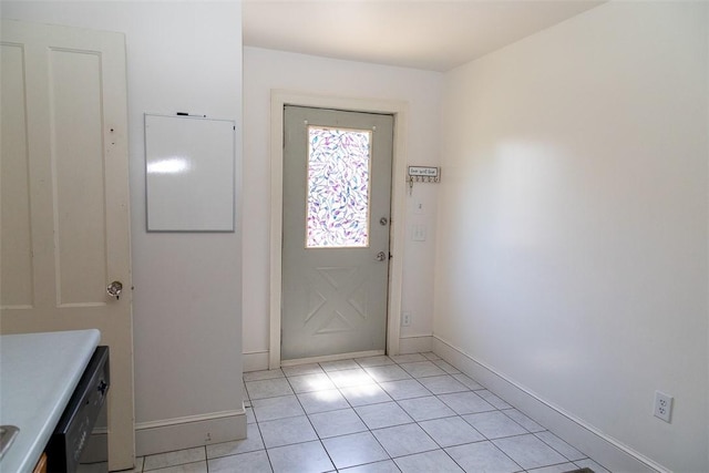 doorway with light tile patterned floors and baseboards