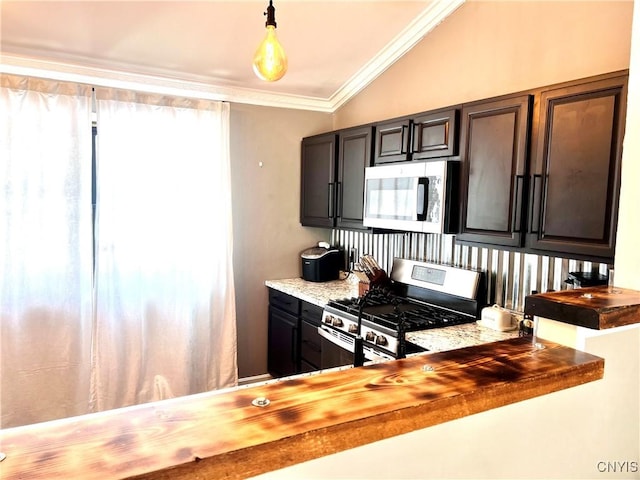 kitchen featuring stainless steel appliances, butcher block counters, decorative light fixtures, and ornamental molding