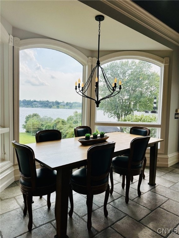 dining area with baseboards, stone tile flooring, and an inviting chandelier