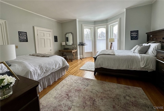 bedroom featuring ornamental molding, access to exterior, and wood finished floors