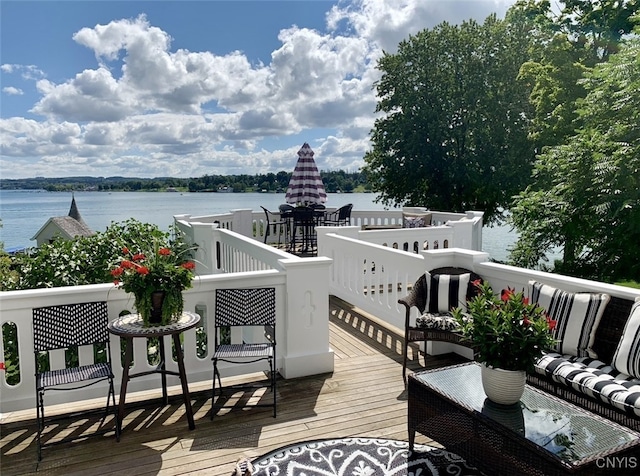 wooden terrace featuring an outdoor hangout area and a water view