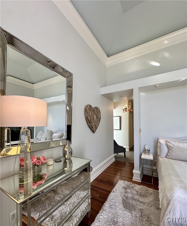 bedroom featuring baseboards, wood finished floors, and crown molding