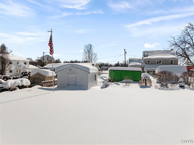 yard covered in snow featuring an outbuilding and a storage unit