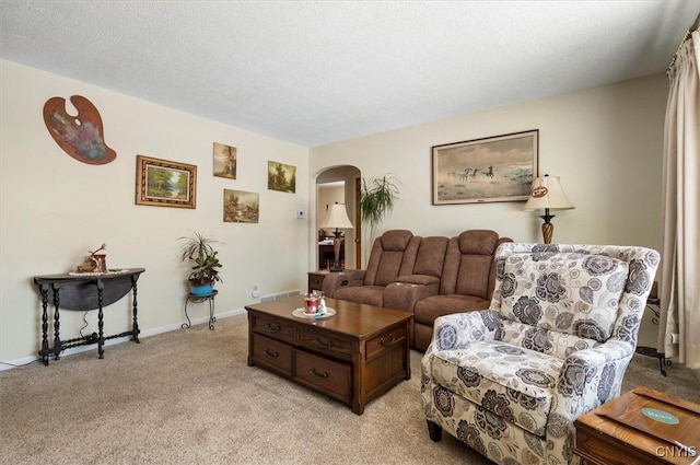 living room with baseboards, arched walkways, a textured ceiling, and light colored carpet