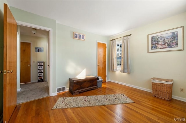 interior space with visible vents, baseboards, and wood finished floors