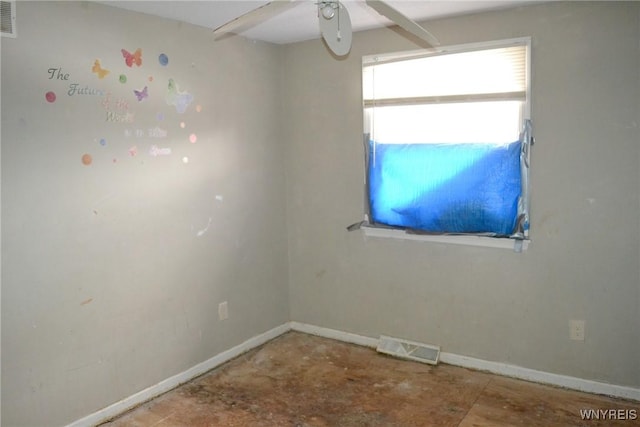 spare room with a ceiling fan, visible vents, and baseboards