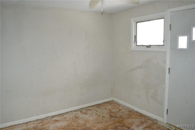 unfurnished room featuring ceiling fan and baseboards