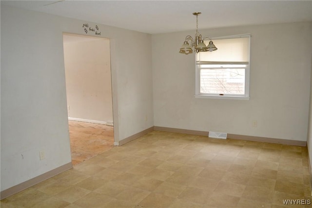 spare room featuring a chandelier, baseboards, visible vents, and light floors