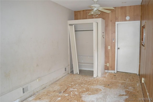 unfurnished bedroom with wooden walls and visible vents