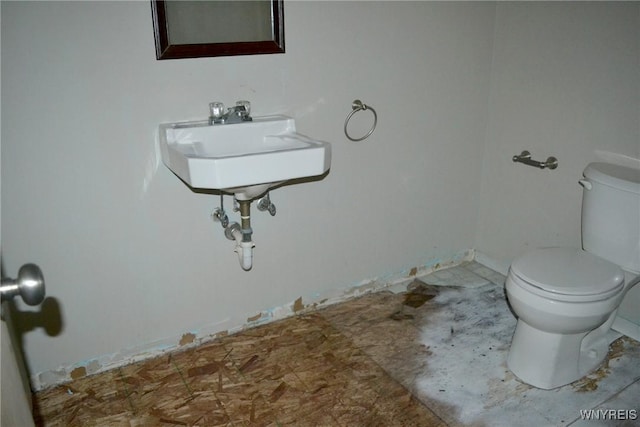 half bathroom featuring a sink and toilet