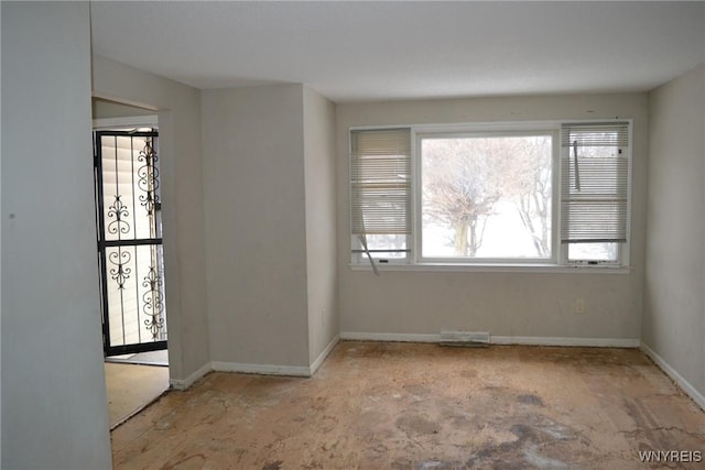 empty room featuring a wealth of natural light and baseboards