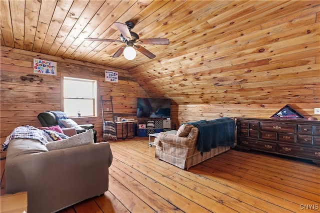 interior space featuring wooden ceiling, light wood-style flooring, wood walls, a ceiling fan, and vaulted ceiling