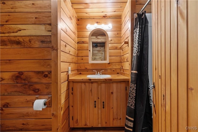 full bathroom with a shower with curtain, wooden ceiling, wood walls, and vanity