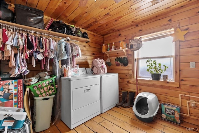 washroom featuring washer and clothes dryer, wood ceiling, wood walls, laundry area, and hardwood / wood-style flooring