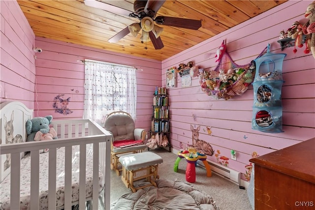 carpeted bedroom featuring a ceiling fan, a nursery area, and wooden ceiling