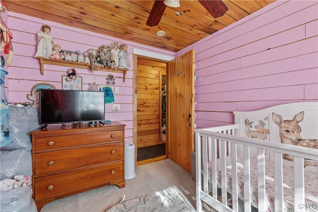 bedroom featuring wood walls, wood ceiling, and light colored carpet