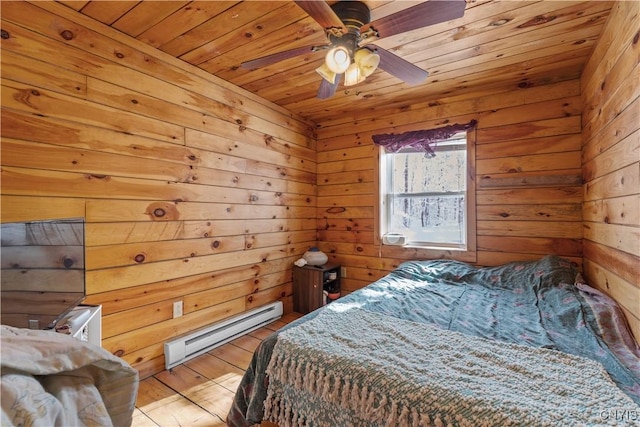 bedroom featuring ceiling fan, a baseboard radiator, wooden ceiling, wood walls, and wood finished floors