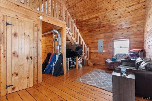 interior space featuring electric panel, wooden ceiling, wood-type flooring, wood walls, and high vaulted ceiling