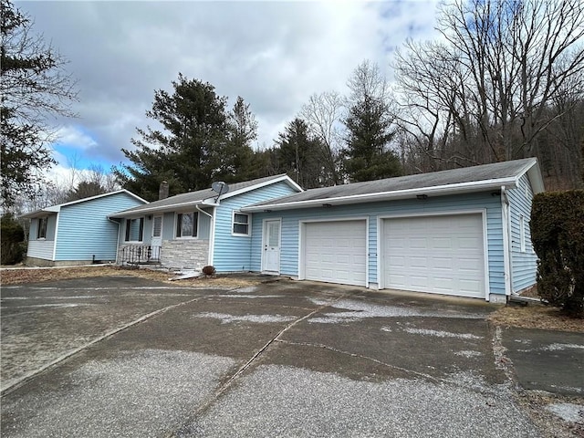 single story home featuring a garage, driveway, and a chimney