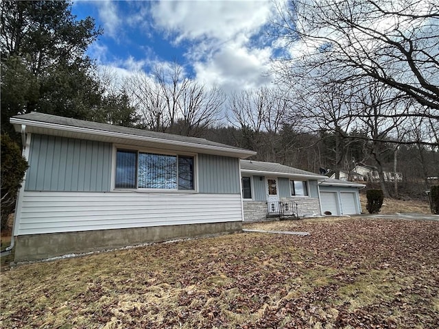 view of front of home featuring an attached garage and stone siding